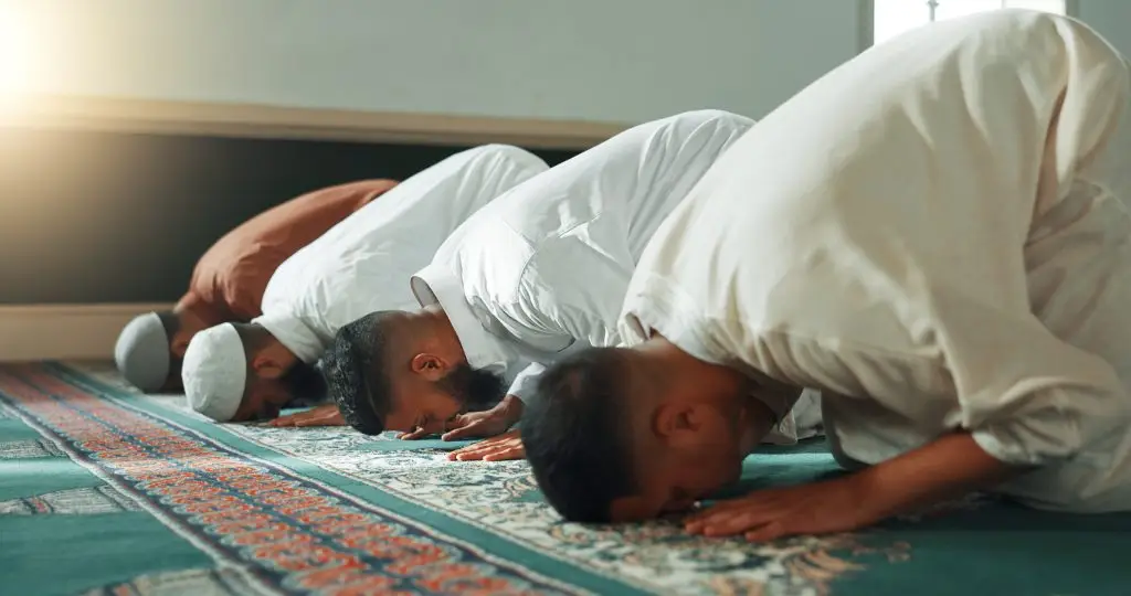 Four Muslim men praying.